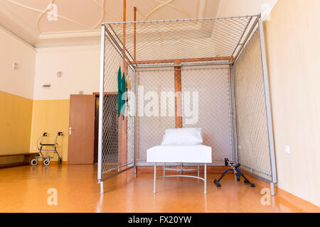 Ein Zimmer in einem Reha Zentrum Teil ein Lazarett. Ein Bett in einem Metallkäfig. Stockfoto