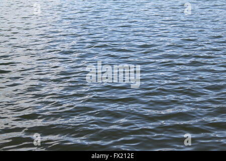 Sonnenlicht auf sanft plätschernden Wasser Hintergrund oder Textur Stockfoto