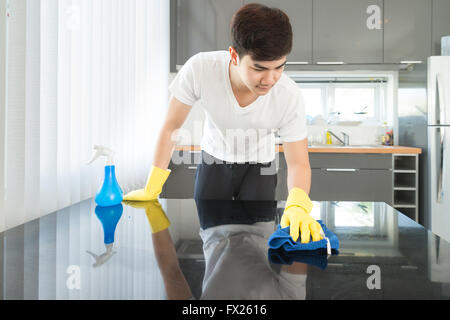 Asiatische junge Mann Reinigung modernen Küche zu Hause Stockfoto