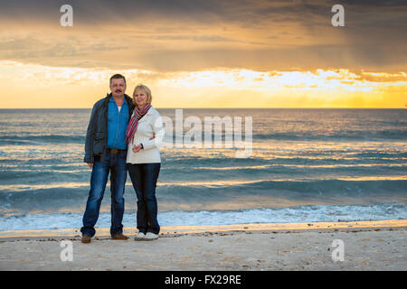 Älteres paar stehen am Strand und zeigt positive Emotionen Stockfoto