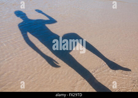 Mannes Schatten am Strand laufen. Stockfoto