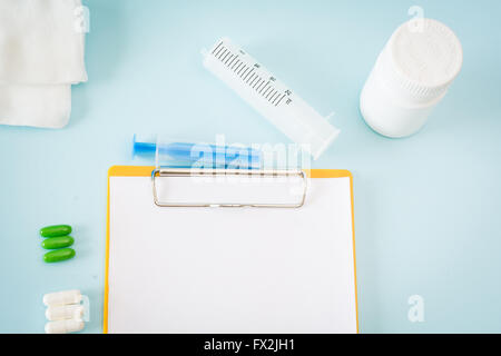 Medizinische Darstellung mit Pillen, Injektion, Gaze, Flasche leer Zwischenablage Blatt. Stockfoto