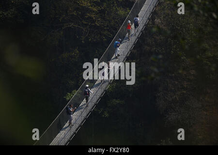 Balthali Village, Nepal. 10. April 2016. Reisenden vorbei an einer Hängebrücke im Balthali Village befindet sich 42 km südöstlich von Kathmandu in Nepal auf Sonntag, 10. April 2016. © Skanda Gautam/ZUMA Draht/Alamy Live-Nachrichten Stockfoto