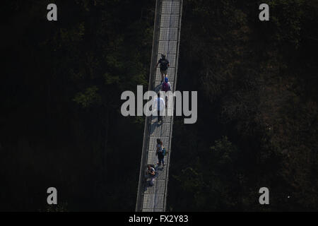 Balthali Village, Nepal. 10. April 2016. Reisenden vorbei an einer Hängebrücke im Balthali Village befindet sich 42 km südöstlich von Kathmandu in Nepal auf Sonntag, 10. April 2016. © Skanda Gautam/ZUMA Draht/Alamy Live-Nachrichten Stockfoto