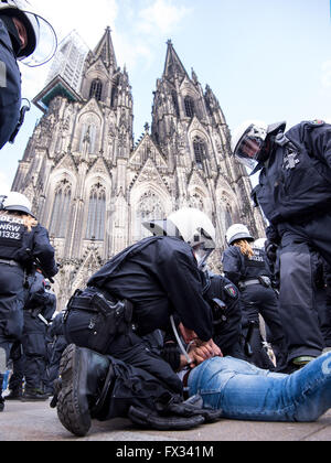 Köln, Deutschland. 10. April 2016. Mitglieder der deutschen Polizei können einen Mann festnehmen, der versucht, eine Kundgebung der nationalistischen Türken, vor dem Dom in Köln, 10. April 2016 stören. Foto: MARIUS BECKER/Dpa/Alamy Live News Stockfoto