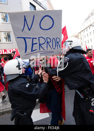 Köln, Deutschland. 10. April 2016. Mitglieder der deutschen Polizei zurückschieben ein Demonstrators mit einem Schild, das "No Terror" während einer Kundgebung der türkischen Nationalisten in Köln, Deutschland, 10. April 2016 liest. Foto: MARIUS BECKER/Dpa/Alamy Live News Stockfoto