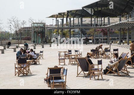 Die Einheimischen sitzen in Liegestühlen auf der Plaza, quadratisch mit verspiegelte Decke von Els Encants Open-Air-Flohmarkt am Glories, Barcelona. Stockfoto