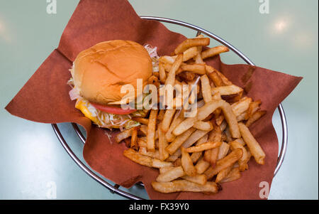 Cheeseburger mit Pommes in einem Metallkorb Stockfoto