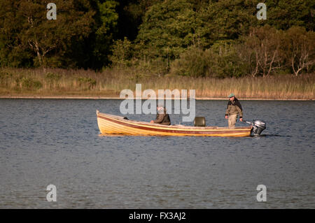 Angeln in Irland und Fischer im Fischerboot oder im Klinkerboot auf dem Lough Leane See im Killarney National Park, County Kerry, Irland Stockfoto