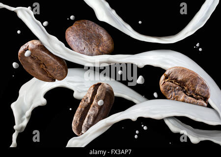 Kaffeebohnen mit Milch Spritzen isoliert auf schwarz Stockfoto