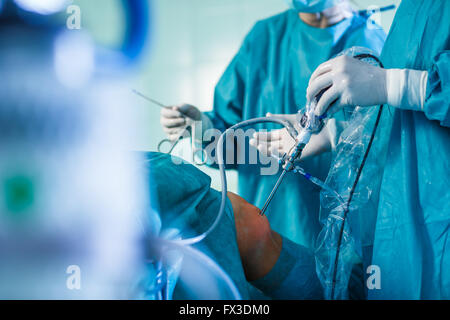 Knie-Chirurgie, orthopädische Operation - zwei Chirurgen, die Durchführung einer Knieoperation bei einem Patienten (flachen DOF; getönten Farbbild) Stockfoto