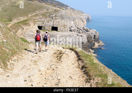 Zwei Frauen zu Fuß auf dem South West Coastal Path in Richtung Tilly Laune Höhlen, Swanage, Doset, England, UK Stockfoto