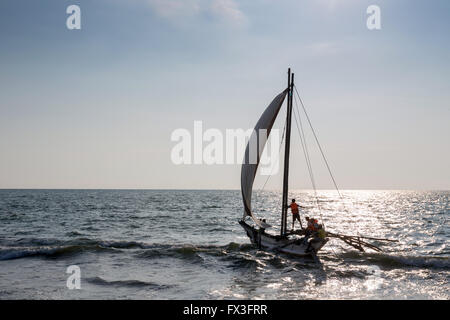 Blick auf traditionelle Fischerei Auslegerboot (Oruva) mit Segel am Strand von Negombo, Sri Lanka Stockfoto