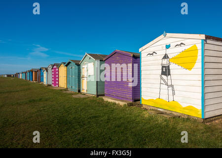 Dovercourt Bay Strandhütten, beginnend oben hell lackiert werden (diese ein mit dem einzigartigen Dovercourt Leuchtturm) Harwich, Großbritannien Stockfoto