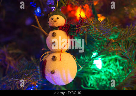 Christmas Tree Ornament der Schneemann mit Weihnachtsbaum Lichter im Hintergrund. Stockfoto