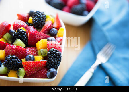 Gesunder frischer Obstsalat mit Erdbeeren, Kiwi, Heidelbeeren, Brombeeren und Mango. Stockfoto