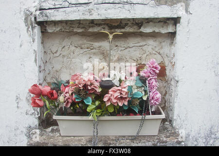 Verwelkt, verblasste Blumen links an ein Grab auf einem Friedhof, New Orleans, Louisiana. Stockfoto