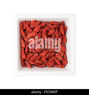 Traditionelle chinesische Medizin - getrocknete Goji-Beeren in eine quadratische Schale isoliert auf weißem Hintergrund Stockfoto