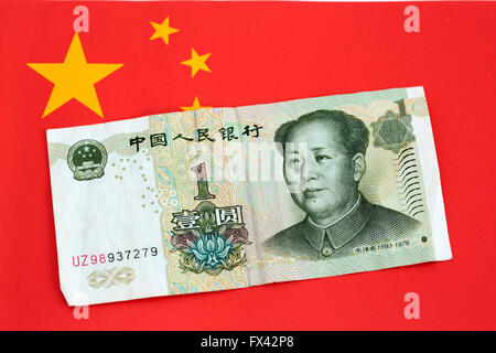 Chinesisches Geld auf eine chinesische Flagge Stockfoto