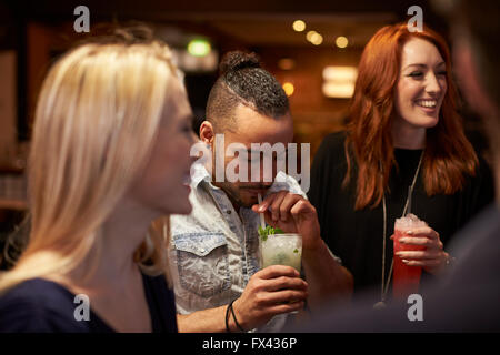 Gruppe von Freunden treffen für Getränke am Abend In der Cocktail-Bar Stockfoto