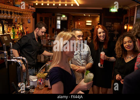 Gruppe von Freunden treffen für Getränke am Abend In der Cocktail-Bar Stockfoto
