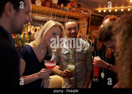 Gruppe von Freunden treffen für Getränke am Abend In der Cocktail-Bar Stockfoto