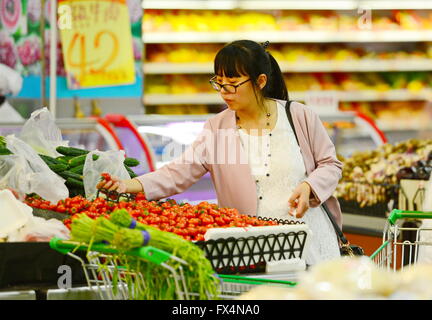 Shijiazhuang, China der Provinz Hebei. 10. April 2016. Eine Frau wählt Gemüse in einem Supermarkt in Baoding Stadt, Provinz Hebei North China, 10. April 2016. Chinas Consumer Price Index (CPI) sah eine 2,3 % über dem Vorjahr Zunahme März, gleich wie im Februar, offizielle Daten Montag zeigte. © Zhu Xudong/Xinhua/Alamy Live-Nachrichten Stockfoto