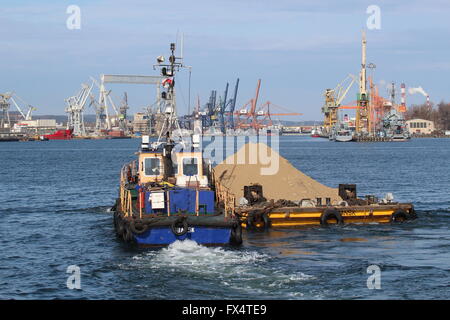 Gdynia, Polen 11. April 2016 Gesamtansicht der Hafen von Gdynia – der polnischen Hafenstadt liegt an der westlichen Küste der Danziger Bucht Ostsee Meer in Gdynia. Im Jahre 1926 gegründet. Im Jahr 2008 wurde es #2 in Containern an der Ostsee. Der Hafen grenzt an Gdynia Naval Base, mit denen es teilt Wasserstraßen aber ist administrativ eine eigenständige Einheit. Lastkahn mit Sand wird auf den Hafengewässern gesehen. Stockfoto