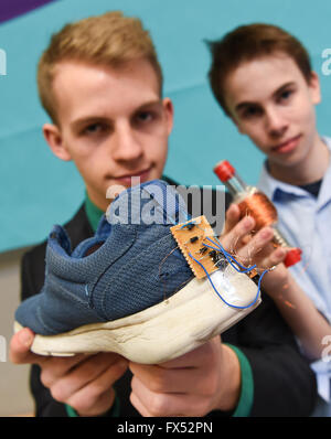 Janosch Ott (15, l) und Robin von Wehrdener (14) der Lichtenberg Schule Darmstadt präsentiert einen Schuh mit einer Leuchtdiode, Teil der Ther project "Laufen Energie", bei den Regionalwettbewerb "Jugend Forscht" ("Jugend forscht") in Darmstadt, Deutschland, 12. April 2016. Die beiden jungen Forscher bauen eine Induktivität in einen Schuh, der Batterien aufladen kann, beim gehen oder laufen. Foto: ARNE DEDERT/dpa Stockfoto