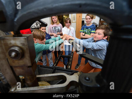 Erfurt, Deutschland. 12. April 2016. Schüler versuchen, ein Kniehebel arbeiten drücken Sie im print-Museum in Erfurt, Deutschland, 12. April 2016. Vom 14. April bis 29. Mai zeigt print Museum die Sonderausstellung "Karte Produktion im Verlag Justus Perthes Gotha". Foto: MARTIN SCHUTT/Dpa/Alamy Live News Stockfoto