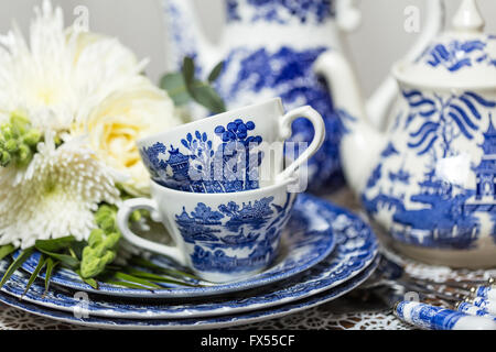 Blaue und weiße Transferware Spode Muster-Tee-Set auf Lace-Tuch für Hochzeit Nachmittagstee mit Blumenstrauß Stockfoto