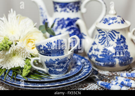 Blaue und weiße Transferware Spode Muster-Tee-Set auf Lace-Tuch für Hochzeit Nachmittagstee mit Blumenstrauß Stockfoto