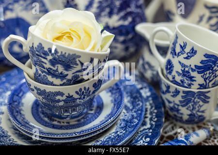 Blaue und weiße Transferware Spode Muster-Tee-Set auf Lace-Tuch für Hochzeit-nachmittags-Tee mit Rosen verstreut Stockfoto