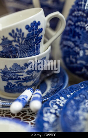 Blaue und weiße Transferware Spode Muster-Tee-Set auf Lace-Tuch für Hochzeit-nachmittags-Tee mit Rosen verstreut Stockfoto