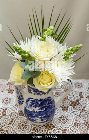 Blaue und weiße Transferware Spode Muster-Tee-Set auf Lace-Tuch für Hochzeit-nachmittags-Tee mit Rosen verstreut Stockfoto