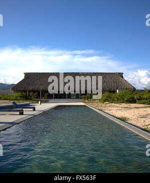 Ozean-Seitenansicht zur wichtigsten Palapa mit Pool. Casa Wabi, Puerto Escondido, Mexiko. Architekt: Tadao Ando, 2015. Stockfoto