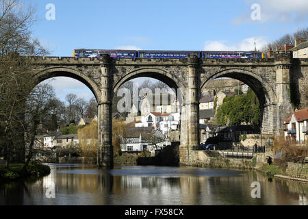 Sonne trifft einen Zug, als es den Fluss Nidd auf dem eleganten Viadukt in Knaresborough, North Yorkshire überquert. Stockfoto