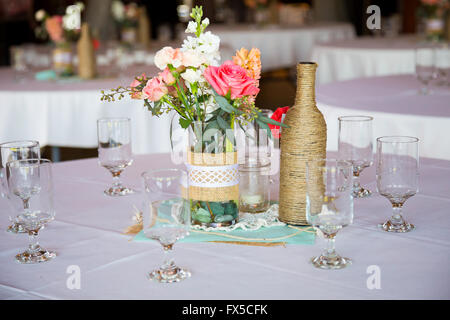 DIY Hochzeit Dekoration Tischdekoration mit Weinflaschen in Sackleinen Schnur gewickelt und rose Blumen. Stockfoto