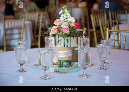 DIY Hochzeit Dekoration Tischdekoration mit Weinflaschen in Sackleinen Schnur gewickelt und rose Blumen. Stockfoto