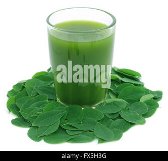 Moringa Blätter mit Extrakt in einem Glas auf weißem Hintergrund Stockfoto