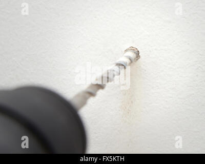 Nahaufnahme von einer Bohrung in einer weißen Betonwand Stockfoto