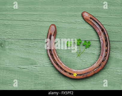 Alte Hufeisen und Kleeblatt Blätter auf Vintage Holz-Hintergrund Stockfoto