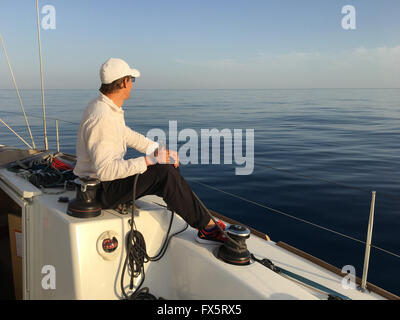 Junger Mann Segeln Yacht Segler halten Hände Seil Stockfoto