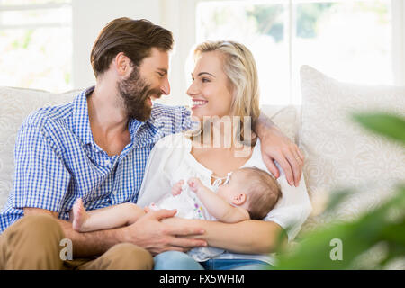 Die Eltern sitzen auf einem Sofa mit Ihrem Kind Stockfoto