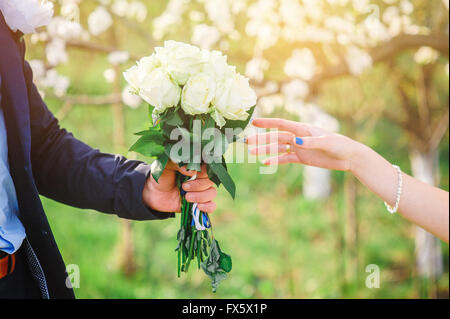 Bräutigam gibt seine Braut eine schöne Hochzeit bouquet Stockfoto