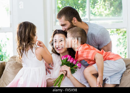 Mutter empfangenden Blumenstrauß von ihrer Familie Stockfoto