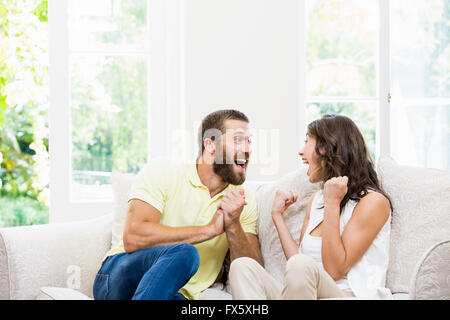 Paar auf Sofa sitzen und Spaß im Wohnzimmer Stockfoto