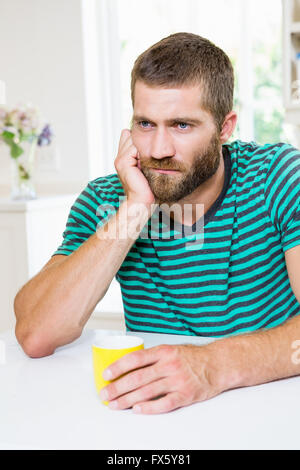 Aufgeregt Mann Kaffeetrinken in Küche Stockfoto