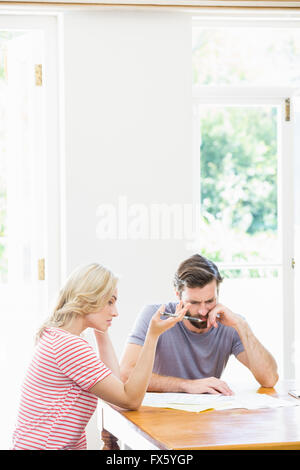 Besorgt junges Paar auf Rechnungen überprüfen Stockfoto