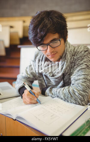 Junger Student auf Schreibtisch Notenlesen Stockfoto